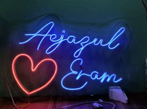 Personalized LED neon sign illuminating a wall with a custom name design.